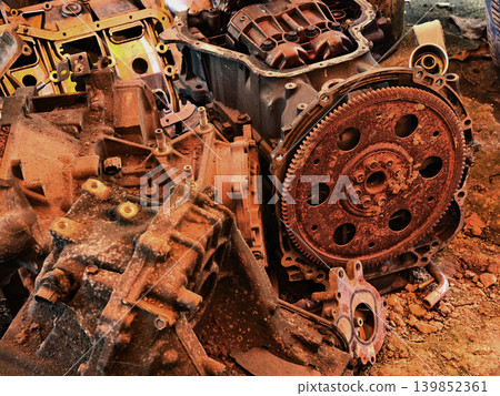 Rusted engine parts and corroded gears scattered across the sandy ground Rusted engine parts and corroded gears scattered across the sandy ground 139852361