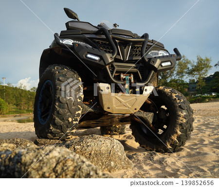 A man engages in extreme ATV riding on sand beach early in the morning A man engages in extreme ATV riding on sand beach early in the morning 139852656