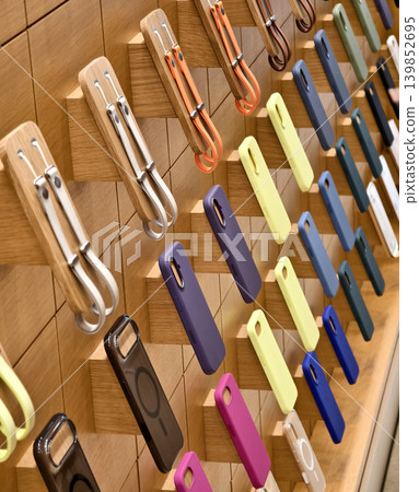 Lively pastel colored phone cases hang systematically displaying diverse textures and styles 139852695