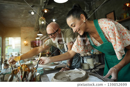 A happy couple makes ceramic plates in a workshop 139852699