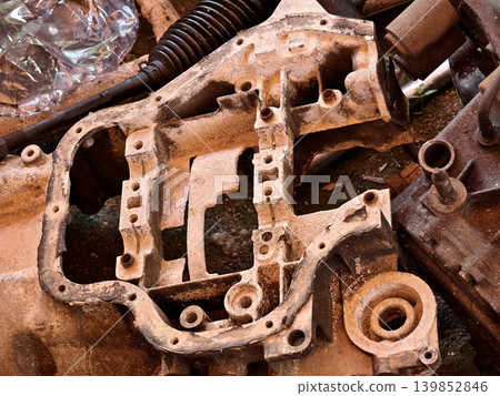 Rusted engine parts and corroded gears scattered across the sandy ground Rusted engine parts and corroded gears scattered across the sandy ground 139852846