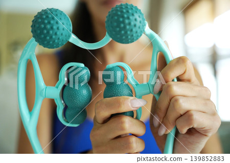 Woman blue sportswear adjusting teal massage roller device Woman blue sportswear adjusting teal massage roller device 139852883