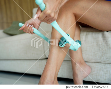 Calf recovery using handheld teal massage roller device Calf recovery using handheld teal massage roller device 139852884