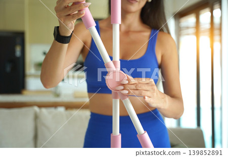 Woman blue sportswear adjusting physiotherapy device to correct his posture 139852891