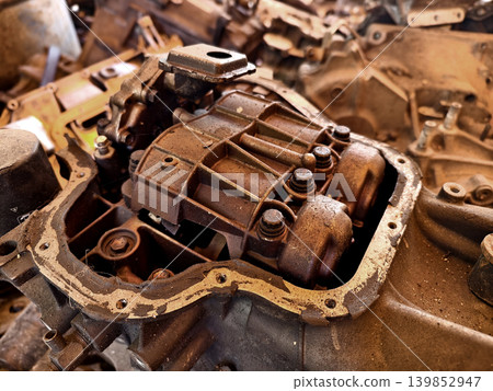 Rusted engine parts and corroded gears scattered across the sandy ground Rusted engine parts and corroded gears scattered across the sandy ground 139852947