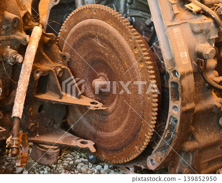 Rusted engine parts and corroded gears scattered across the sandy ground Rusted engine parts and corroded gears scattered across the sandy ground 139852950