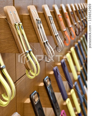 Lively pastel colored phone cases hang systematically displaying diverse textures and styles 139852969