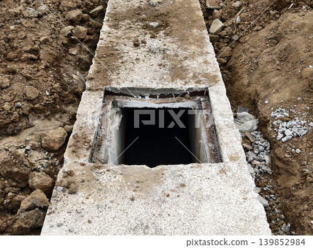 Narrow ditch with reinforcement, waterproof concrete trench bounded by soil and support stakes 139852984