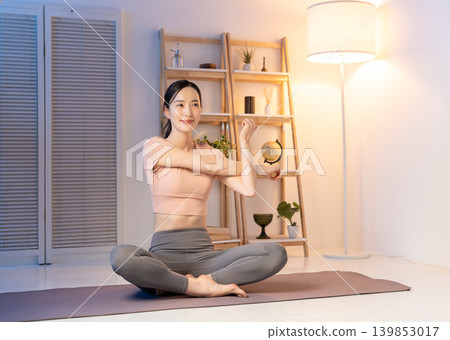 A woman doing stretches at night A woman doing stretches at night 139853017