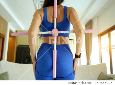 Woman blue sportswear using physiotherapy device to correct his posture Woman blue sportswear using physiotherapy device to correct his posture 139853096