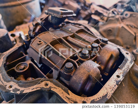 Rusted engine parts and corroded gears scattered across the sandy ground Rusted engine parts and corroded gears scattered across the sandy ground 139853119