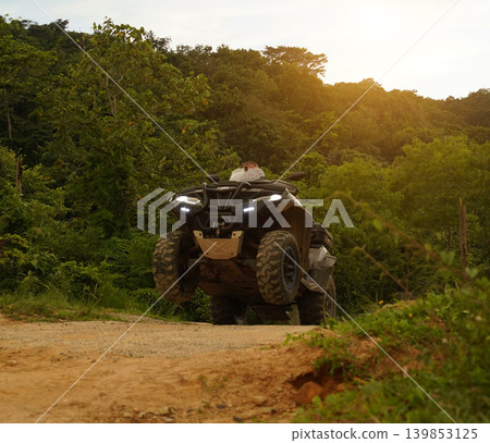 A man engages in extreme ATV riding on mountains in the evening A man engages in extreme ATV riding on mountains in the evening 139853125