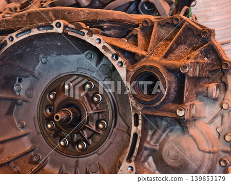 Rusted engine parts and corroded gears scattered across the sandy ground Rusted engine parts and corroded gears scattered across the sandy ground 139853179