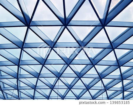 Glass canopy showcasing repeating geometric frames and day light 139853185