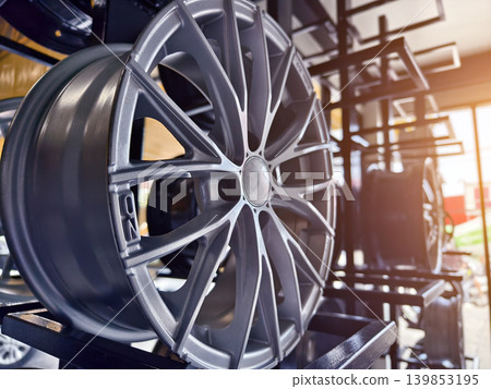 Luxurious automotive display featuring chrome wheels and warm lighting Luxurious automotive display featuring chrome wheels and warm lighting 139853195