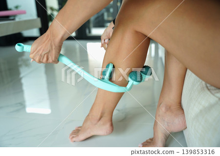 Calf recovery using handheld teal massage roller device 139853316