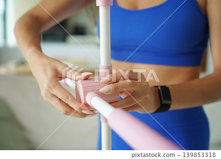 Woman blue sportswear adjusting physiotherapy device to correct his posture 139853318