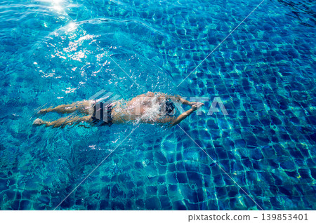 Young athletic man swimming in the swimming pool Young athletic man swimming in the swimming pool 139853401