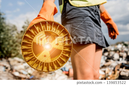 Woman volunteer helps clean the field of nuclear waste and plastic garbage. Woman volunteer helps clean the field of nuclear waste and plastic garbage. 139853522