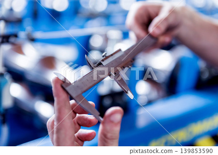 Male hands hold vernier caliper and measure steel collar. Male hands hold vernier caliper and measure steel collar. 139853590