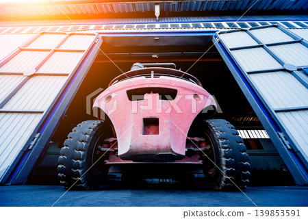 The big industrial forklift drives into the warehouse. The big industrial forklift drives into the warehouse. 139853591