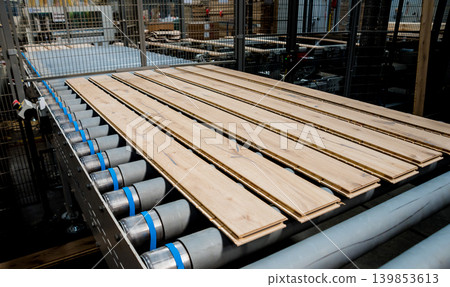 Production line of the wooden floor factory. CNC automatic woodworking machine. Production line of the wooden floor factory. CNC automatic woodworking machine. 139853613