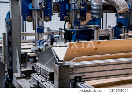 Production line of the wooden floor factory. CNC automatic woodworking machine. Production line of the wooden floor factory. CNC automatic woodworking machine. 139853621
