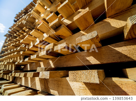 Stack of natural rough wooden boards. Wooden boards, lumber, industrial wood. 139853643