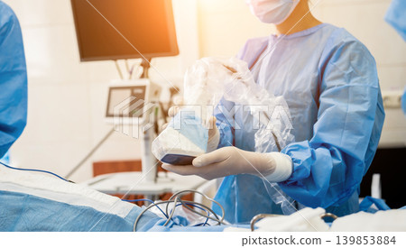 The surgeon uses a portable fluorescence imaging device during breast removal. The surgeon uses a portable fluorescence imaging device during breast removal. 139853884
