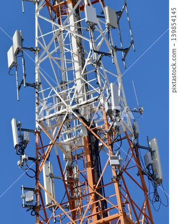 Colorful communications mast. Industrial tower showcasing weathered steel framework and devices 139854145