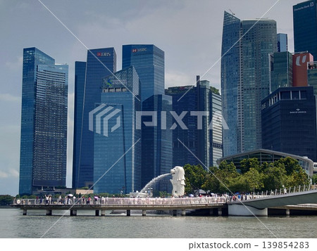 The Merlion statue stands against the backdrop of Singapore's financial district's skyscrapers. The Merlion statue stands against the backdrop of Singapore's financial district's skyscrapers. 139854283