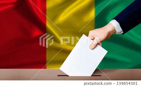 Guinea Parliamentary vote. Hand placing a ballot in ballot box with the Guinean flag in the background 139854301