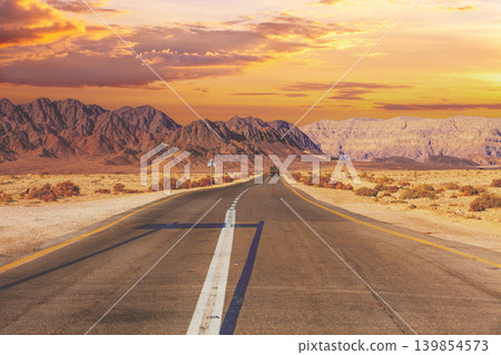 Driving a car on the mountain road in Israel. Desert landscape. Empty road. View from the car of mountain landscape on a sunny day with a clear blue sky. Israel Driving a car on the mountain road in Israel. Desert landscape. Empty road. View from the car of mountain landscape on a sunny day with a clear blue sky. Israel 139854573