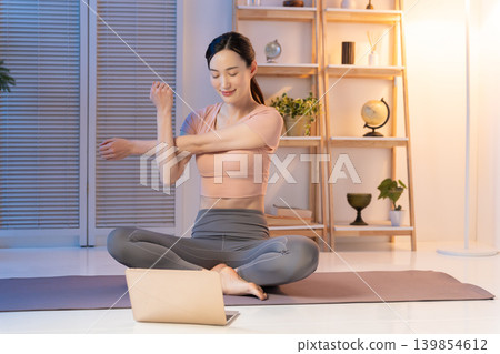 一位女士在夜間看影片時伸了個懶腰。 139854612