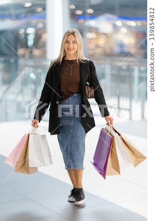 Woman walking with shopping bags in mall Woman walking with shopping bags in mall 139854812