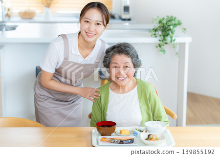 A caregiver and a senior woman preparing a meal A caregiver and a senior woman preparing a meal 139855192