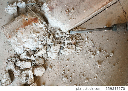 Breaking concrete floor with electric jackhammer close up 139855670