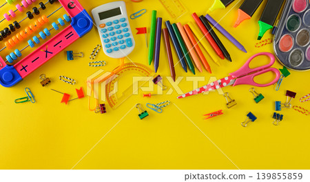 Colorful School Supplies and Stationery Items Scattered on Bright Yellow Background, Flat Lay Composition with Copy Space Colorful School Supplies and Stationery Items Scattered on Bright Yellow Background, Flat Lay Composition with Copy Space 139855859