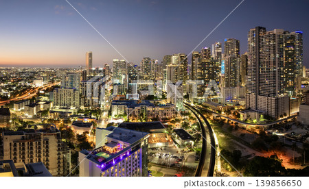 Railroad and public train line through downtown Miami in Florida, USA. Essential transport infrastructure in a city of modern high-rises at night Railroad and public train line through downtown Miami in Florida, USA. Essential transport infrastructure in a city of modern high-rises at night 139856650