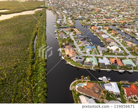 Evening light over Florida waterfront community. Expensive homes and luxury mansions illuminated by sundown sky. Evening light over Florida waterfront community. Expensive homes and luxury mansions illuminated by sundown sky. 139856671