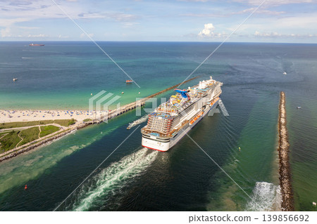 Aerial panorama of Miami, Florida with luxury cruise liner sailing through harbor channel. Waterfront skyline with hotels and apartments. 139856692