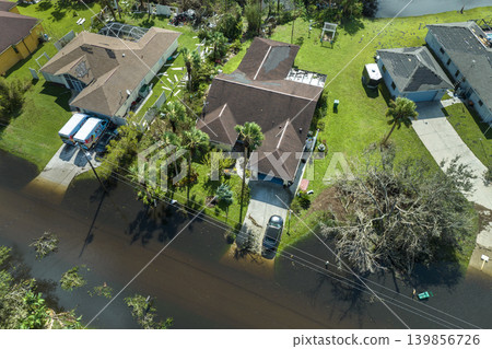 Consequences of natural disaster. Heavy flood with high water surrounding residential houses after hurricane Ian rainfall in Florida residential area 139856726