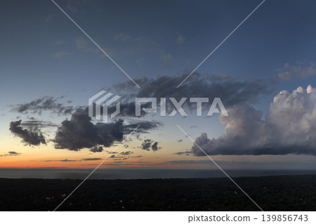 Amazing sunset skyscape. Evening sky with bright colorful orange and yellow clouds over dark landscape Amazing sunset skyscape. Evening sky with bright colorful orange and yellow clouds over dark landscape 139856743