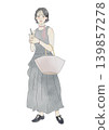A young woman holding an iced cafe latte; wearing summer clothes, a dress. 139857278