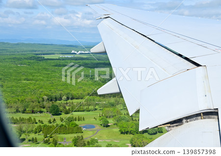 Looking from the airplane window with stunning skyscapes and landscape with airplane wing. Travel and transportation concept. Looking from the airplane window with stunning skyscapes and landscape with airplane wing. Travel and transportation concept. 139857398