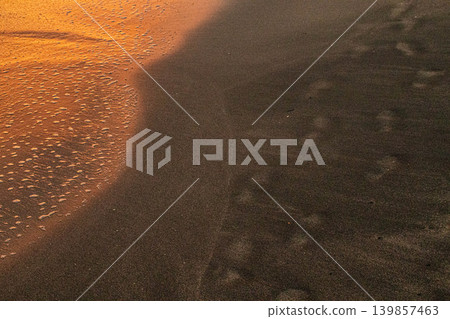 Waves and footprints on the beach (sunset) Waves and footprints on the beach (sunset) 139857463