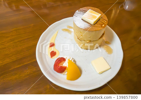 Thick pancakes served with fruit and cream on a wooden table Thick pancakes served with fruit and cream on a wooden table 139857800