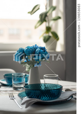 Elegant blue glass bowls and flowers on modern dining table Elegant blue glass bowls and flowers on modern dining table 139858083
