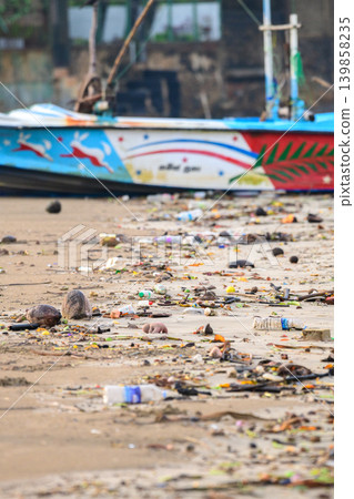 Plastic pollution and marine debris on a sandy beach with a fishing boat in the coastal environment Plastic pollution and marine debris on a sandy beach with a fishing boat in the coastal environment 139858235