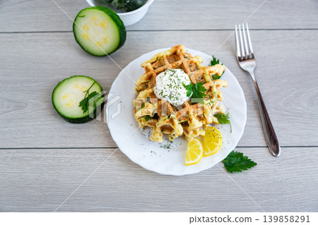 crispy zucchini waffles served with sour cream and parsley leaves crispy zucchini waffles served with sour cream and parsley leaves 139858291